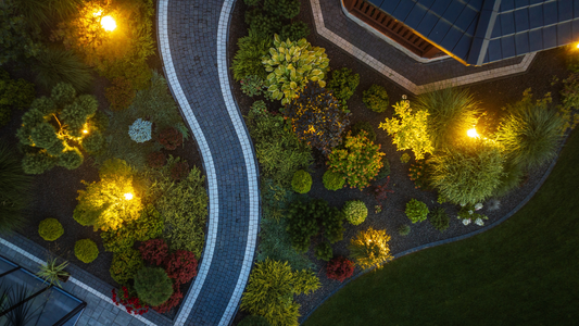 Backyard outdoor living space illuminated with warm landscape lighting at dusk