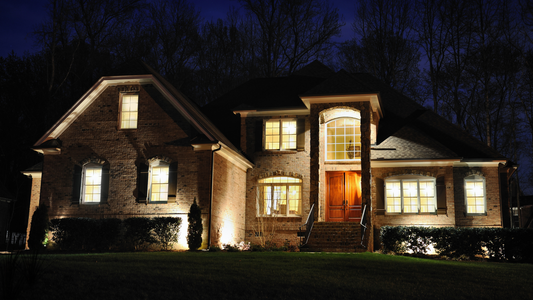 Front yard illuminated with warm low-voltage landscape lighting at dusk