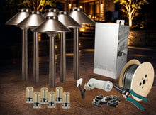 Load image into Gallery viewer, Outdoor landscape light kit with six bronze-colored bollard lights, a silver metal junction box, a spool of wire, LED bulbs, connectors, and a wire cutter, arranged on a stone patio at night with warm house lighting in the background.
